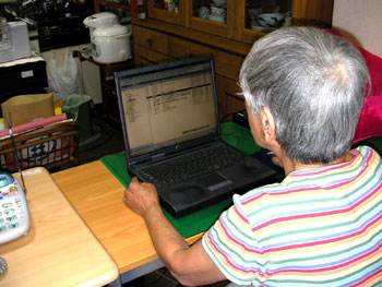 パソコンを操作する独居高齢者